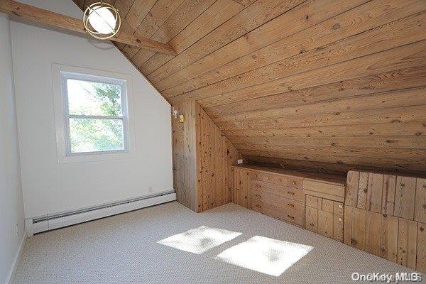 bonus room with baseboard heating, wooden ceiling, wood walls, carpet floors, and lofted ceiling