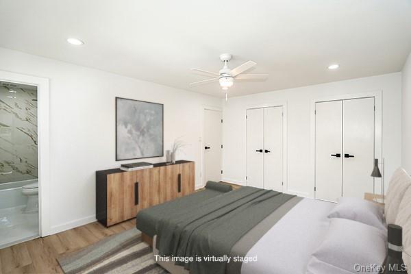 bedroom with ensuite bath, multiple closets, ceiling fan, and light hardwood / wood-style flooring