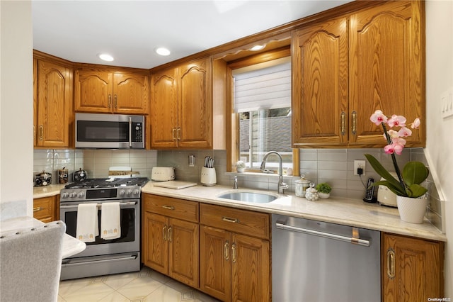 kitchen with decorative backsplash, appliances with stainless steel finishes, light tile patterned floors, and sink