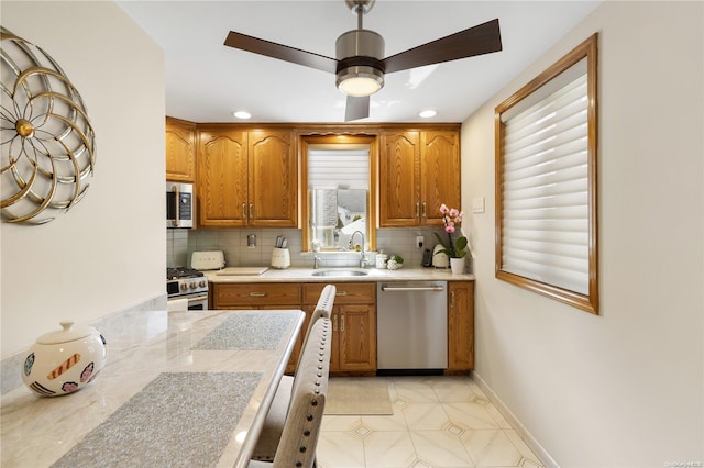 kitchen featuring backsplash, ceiling fan, sink, and stainless steel appliances