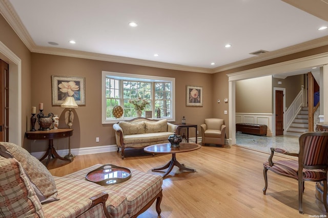 living room with light wood-type flooring, baseboard heating, and crown molding