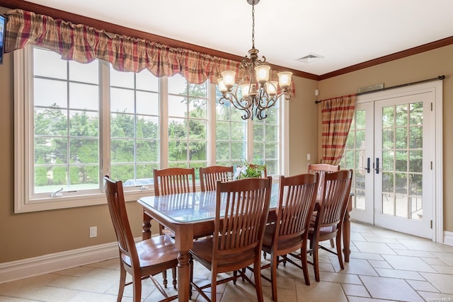 dining area featuring a notable chandelier, a healthy amount of sunlight, ornamental molding, and french doors