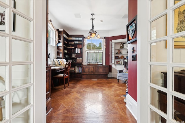 office area with dark parquet floors and an inviting chandelier