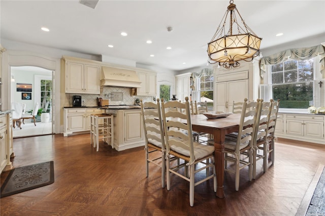 dining room with dark parquet floors and a notable chandelier