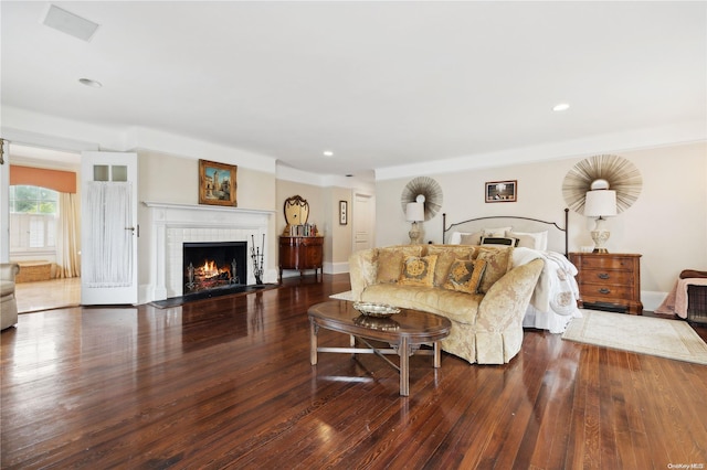 living room with dark hardwood / wood-style flooring and a tiled fireplace