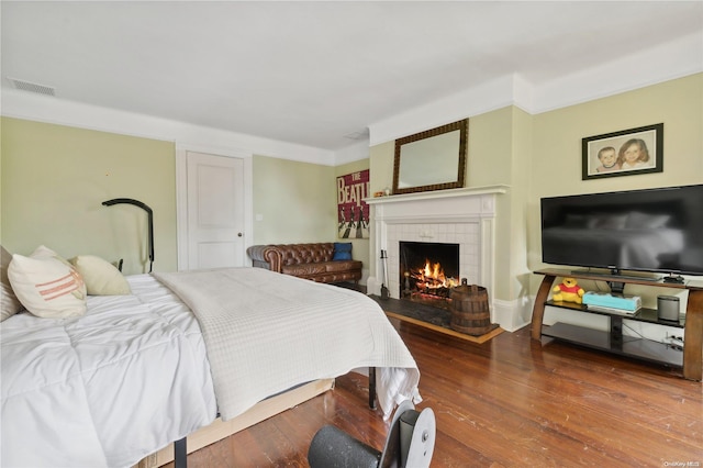 bedroom featuring hardwood / wood-style flooring and a fireplace