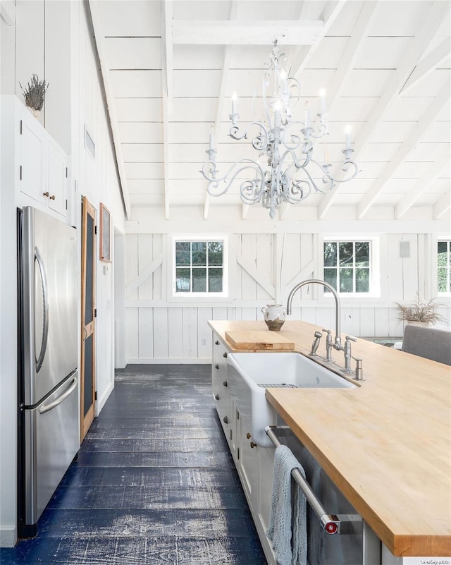 kitchen with plenty of natural light, dark hardwood / wood-style flooring, butcher block counters, and stainless steel refrigerator