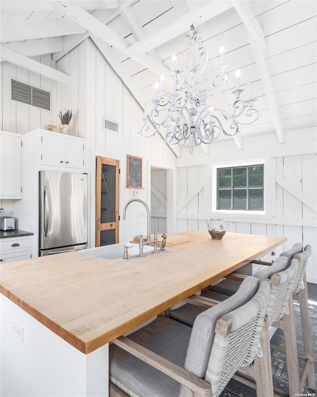 dining room with breakfast area, wooden walls, beam ceiling, hardwood / wood-style flooring, and high vaulted ceiling