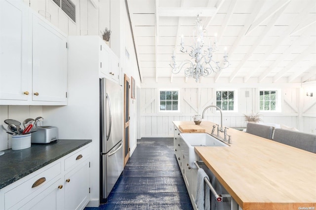 kitchen featuring wood counters, dark hardwood / wood-style floors, stainless steel refrigerator, and plenty of natural light