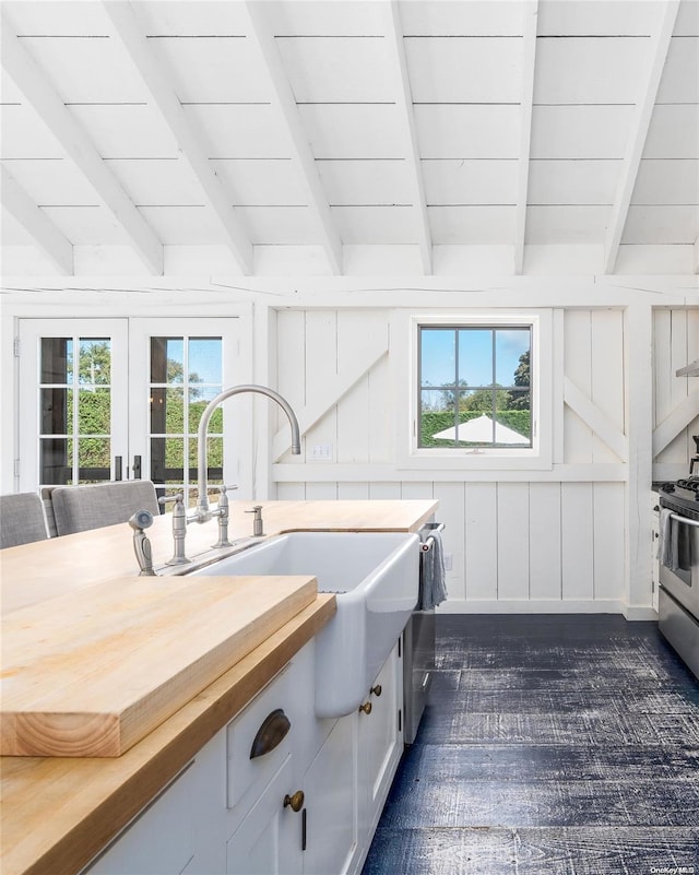 kitchen featuring beam ceiling, butcher block counters, a wealth of natural light, and sink