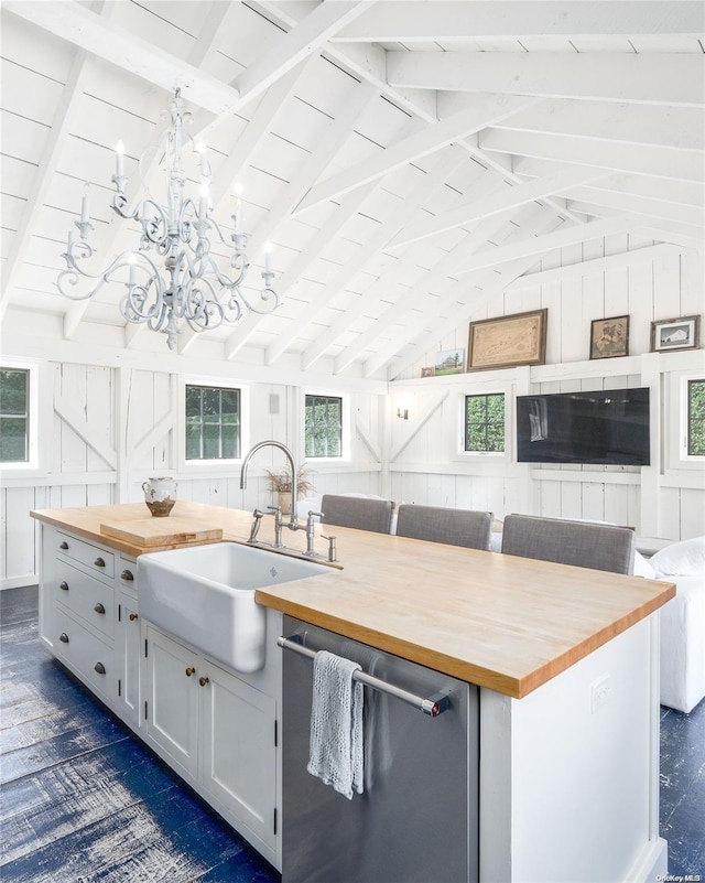 kitchen with butcher block counters, sink, a kitchen island, and stainless steel dishwasher