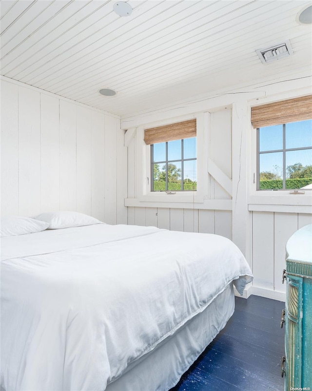 bedroom featuring dark hardwood / wood-style flooring, wooden ceiling, and wooden walls