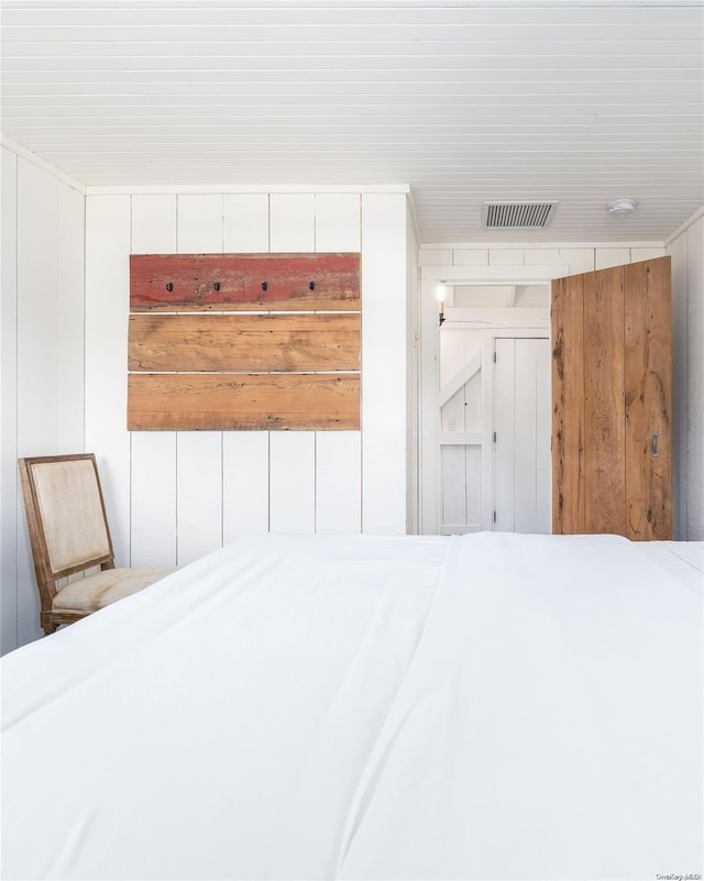 unfurnished bedroom featuring wooden walls