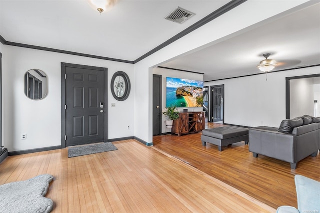 entrance foyer with ceiling fan, light wood-type flooring, and crown molding