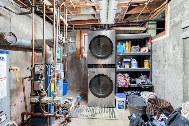 laundry room featuring water heater and stacked washing maching and dryer