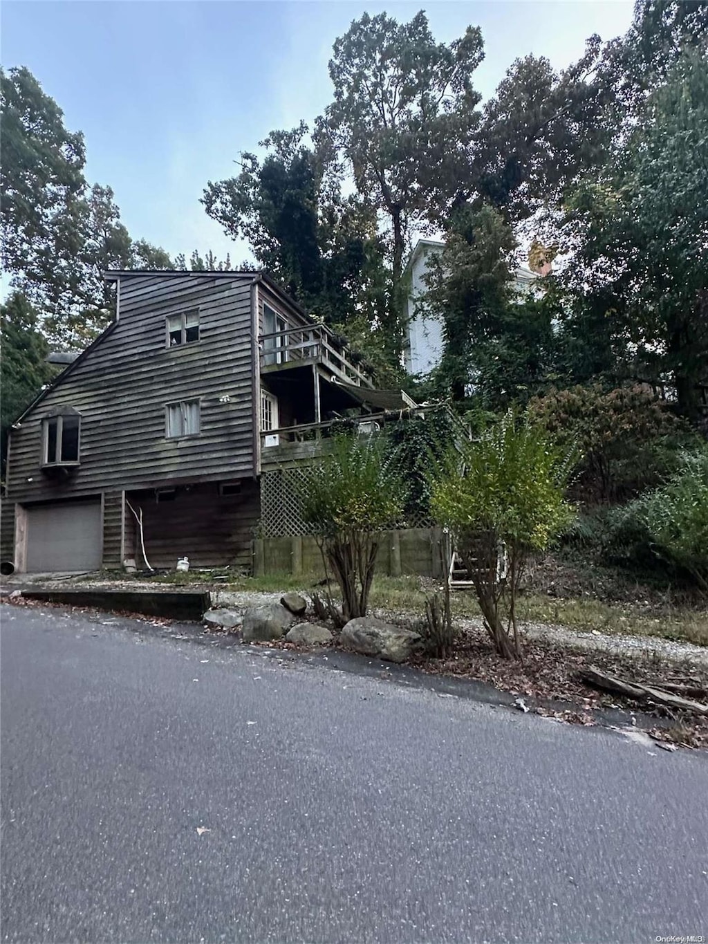 view of side of home featuring a garage and a wooden deck