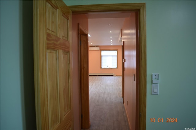 corridor featuring a wall mounted air conditioner, light wood-type flooring, and a baseboard radiator