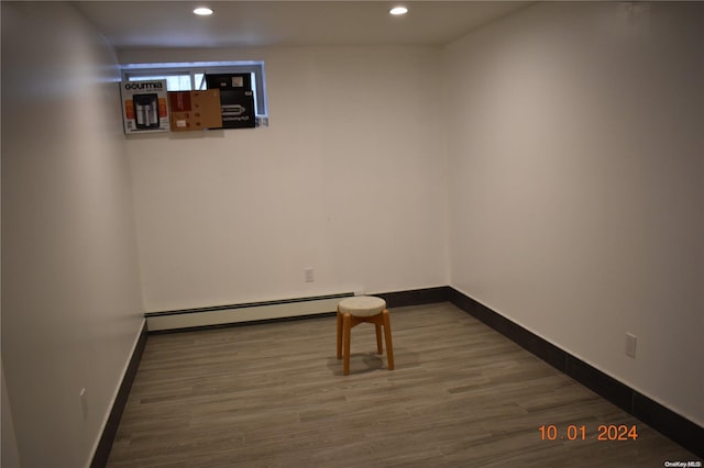 spare room featuring a baseboard radiator and hardwood / wood-style flooring