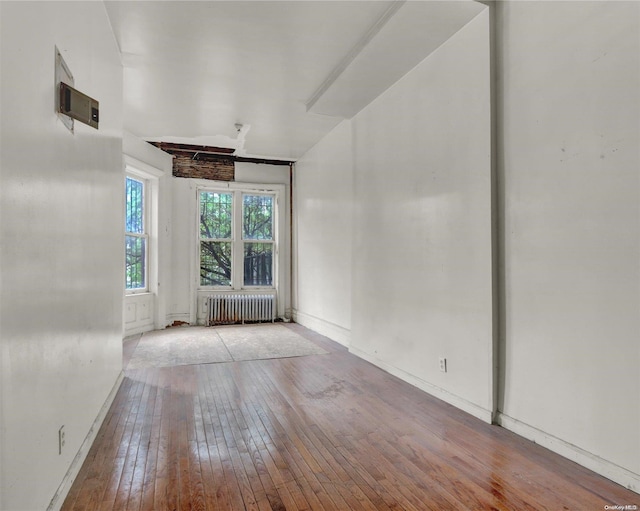 475 W 140th St, New York Manhattan, NY 10031 - empty room featuring radiator, wood-type flooring, and baseboards