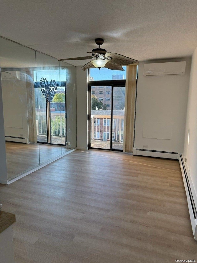 unfurnished room with a wall mounted air conditioner, ceiling fan, a wall of windows, and a baseboard radiator