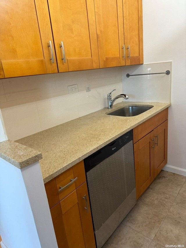 kitchen featuring dishwasher, light stone countertops, sink, and tasteful backsplash