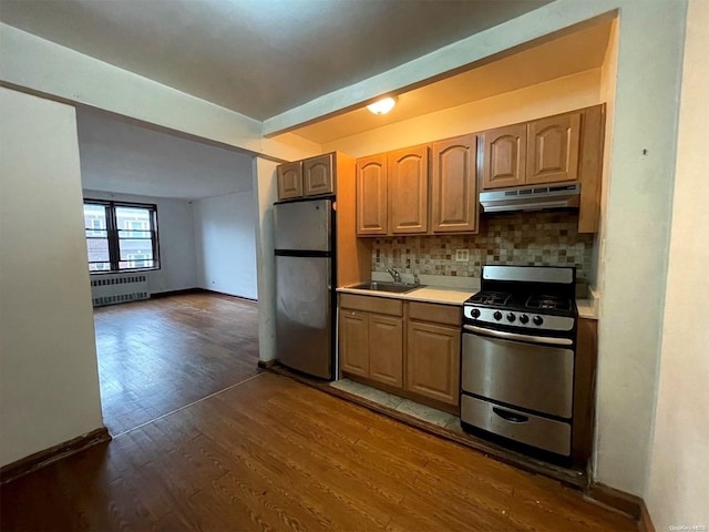 37-27 86th St Unit 4A, Jackson Heights, NY 11372 - kitchen with appliances with stainless steel finishes, radiator heating unit, under cabinet range hood, dark wood-type flooring, and backsplash