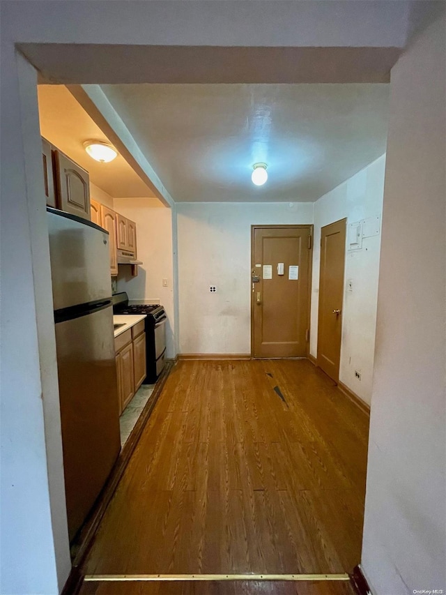37-27 86th St Unit 4A, Jackson Heights, NY 11372 - kitchen featuring freestanding refrigerator, gas stove, wood finished floors, under cabinet range hood, and light countertops