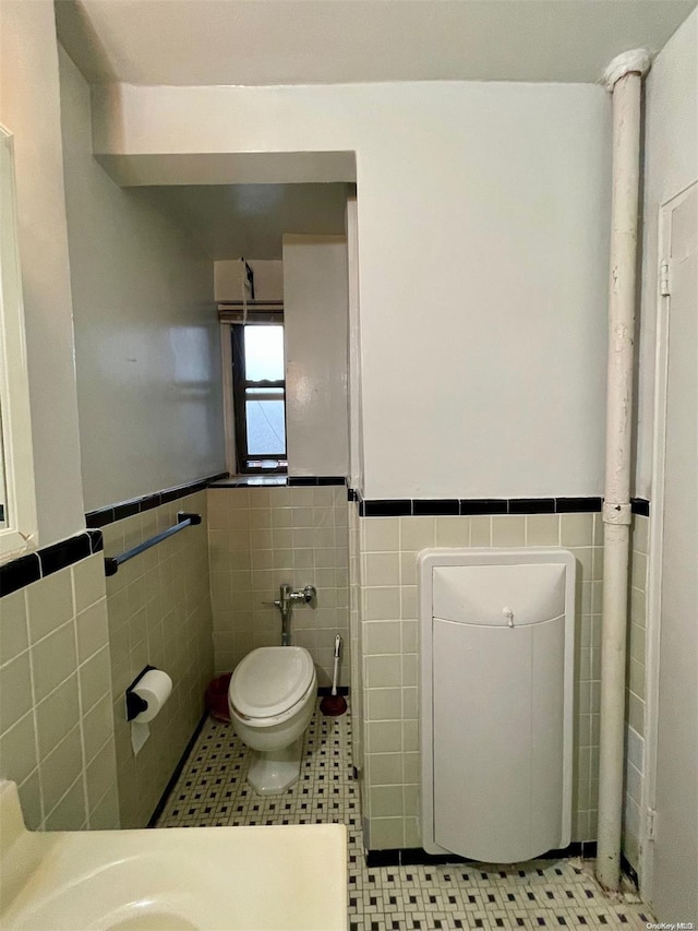 37-27 86th St Unit 4A, Jackson Heights, NY 11372 - bathroom featuring tile walls, wainscoting, and tile patterned flooring