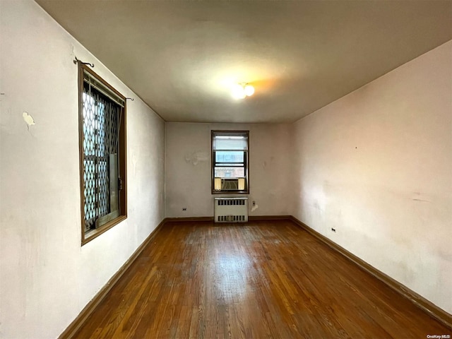 37-27 86th St Unit 4A, Jackson Heights, NY 11372 - unfurnished room with radiator heating unit, wood finished floors, and cooling unit