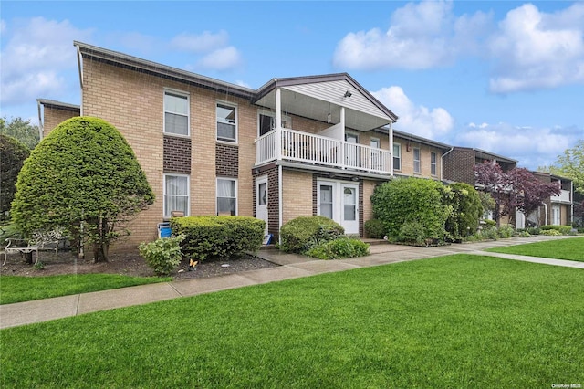 townhome / multi-family property featuring a balcony and a front yard