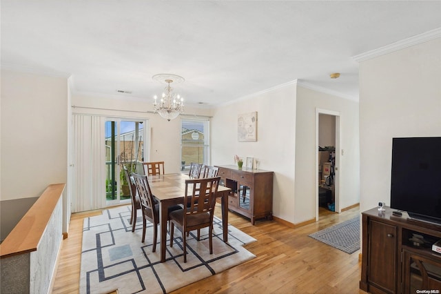 dining room featuring light hardwood / wood-style flooring, a notable chandelier, and ornamental molding