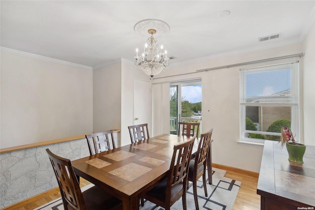 dining room featuring a chandelier, crown molding, and light hardwood / wood-style flooring