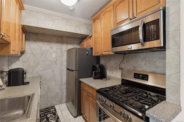 kitchen with decorative backsplash, ornamental molding, stainless steel appliances, sink, and light tile patterned flooring