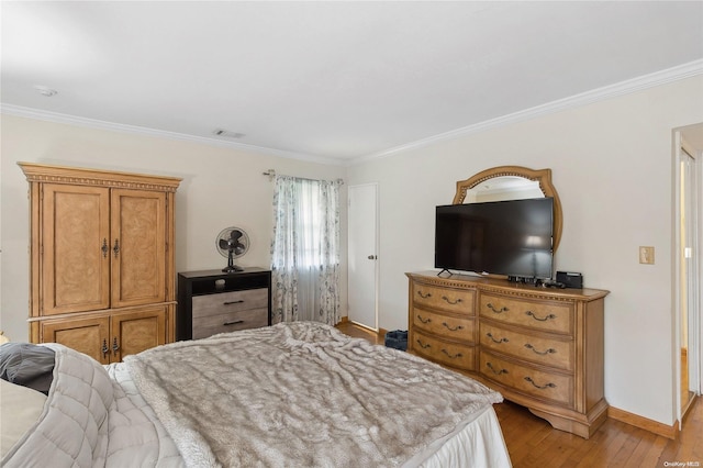 bedroom with light hardwood / wood-style floors and ornamental molding