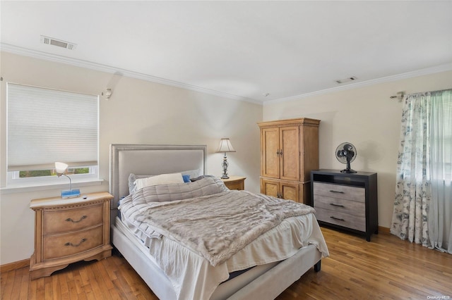 bedroom with wood-type flooring and ornamental molding