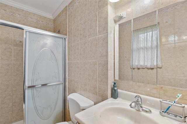 bathroom featuring sink, crown molding, toilet, tile walls, and walk in shower