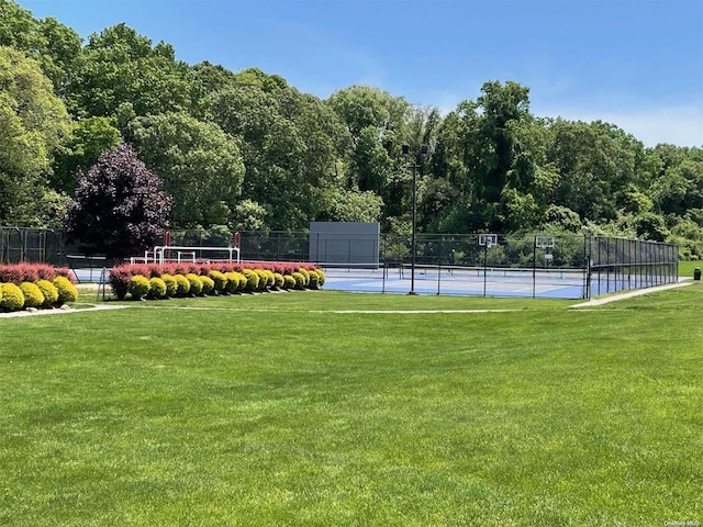 view of tennis court featuring a lawn