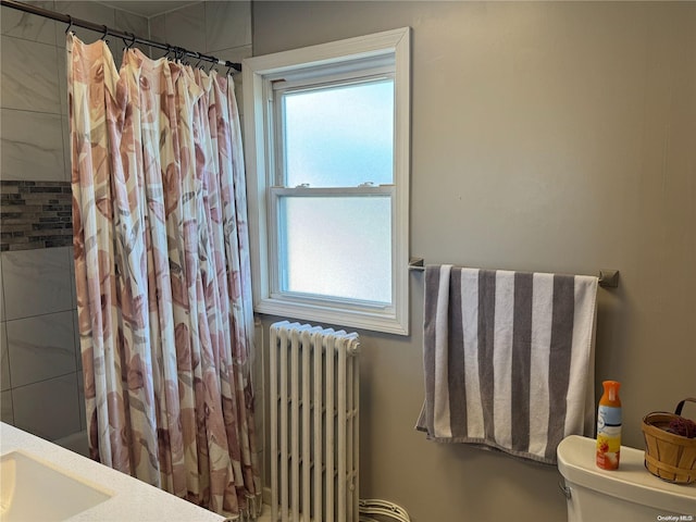 bathroom with vanity, toilet, and radiator