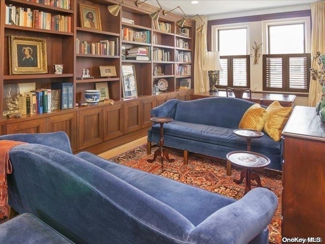 sitting room with wood-type flooring and built in features