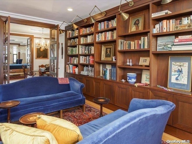 living area featuring hardwood / wood-style flooring and a chandelier