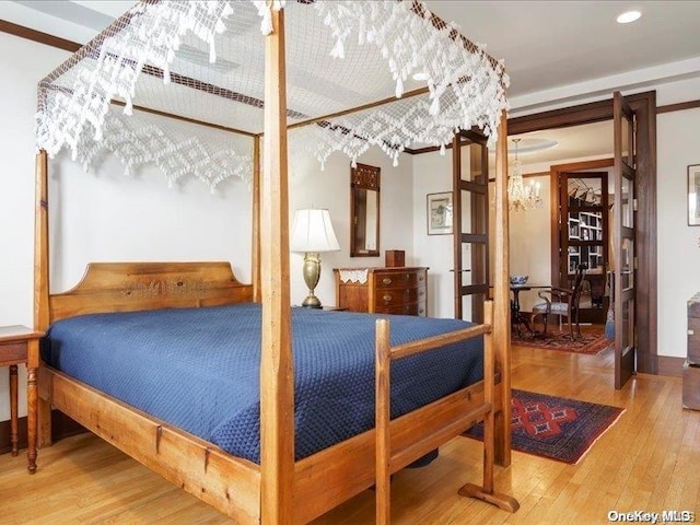 bedroom featuring hardwood / wood-style flooring and a chandelier