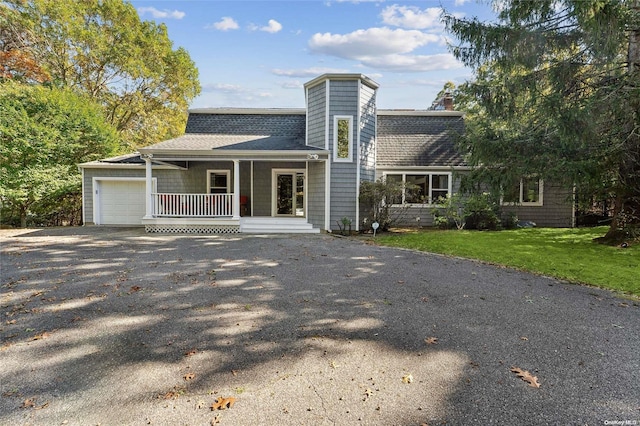 view of front of house featuring a front yard, a porch, and a garage