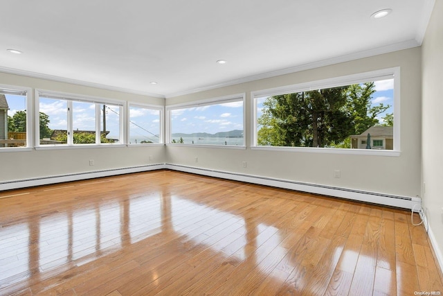 unfurnished sunroom featuring plenty of natural light and a baseboard heating unit