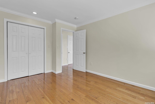 unfurnished bedroom featuring a closet, crown molding, and light hardwood / wood-style flooring