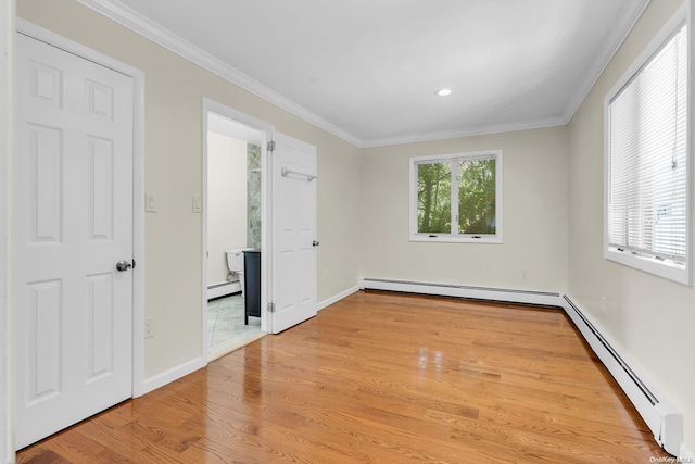 unfurnished room featuring crown molding, a baseboard heating unit, and light wood-type flooring