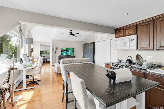 kitchen featuring light wood-type flooring, stainless steel range with electric stovetop, dark brown cabinetry, vaulted ceiling, and ceiling fan