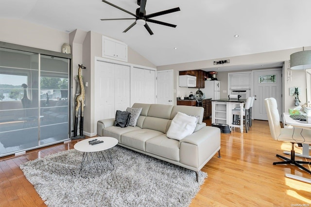 living room with light hardwood / wood-style floors, ceiling fan, and lofted ceiling