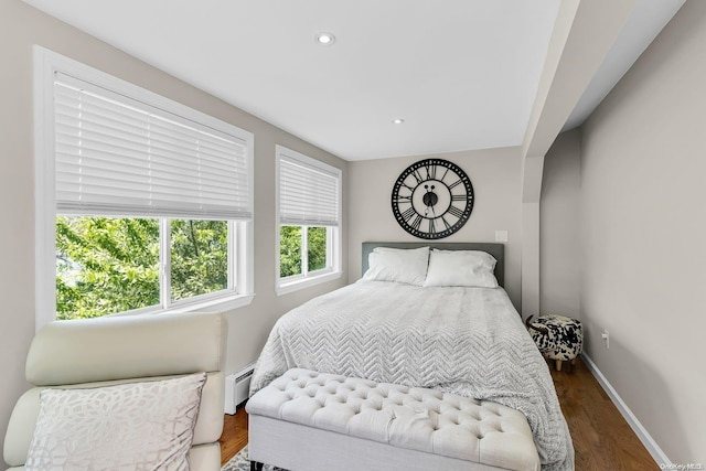 bedroom with dark wood-type flooring and a baseboard heating unit