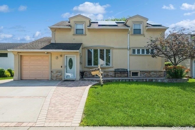 view of front of property with solar panels, a garage, and a front yard