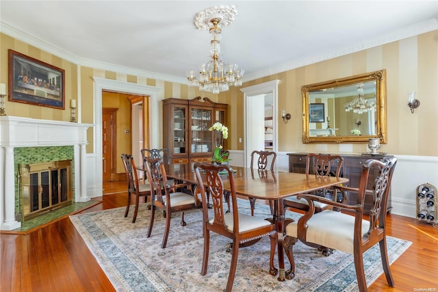75 Oak Neck Ln, West Islip, NY 11795 - dining area with wood finished floors, a chandelier, crown molding, a tile fireplace, and wainscoting